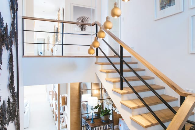 Escalier en bois clair et rampe métallique d’un duplex