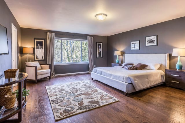 Grande chambre avec lit double et tapis à motifs