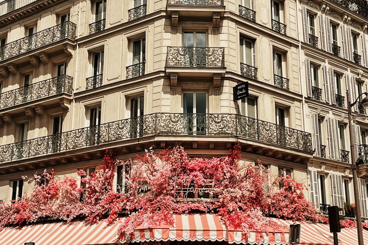 Immeuble haussmannien aux balcons filants, une vigne vierge rouge sur la façade