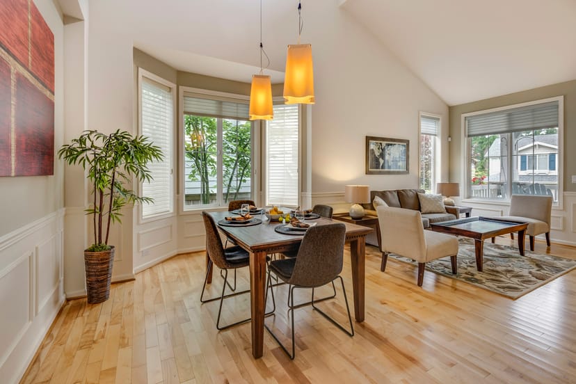 Pièce de vie avec coin repas, parquet clair et suspensions orange